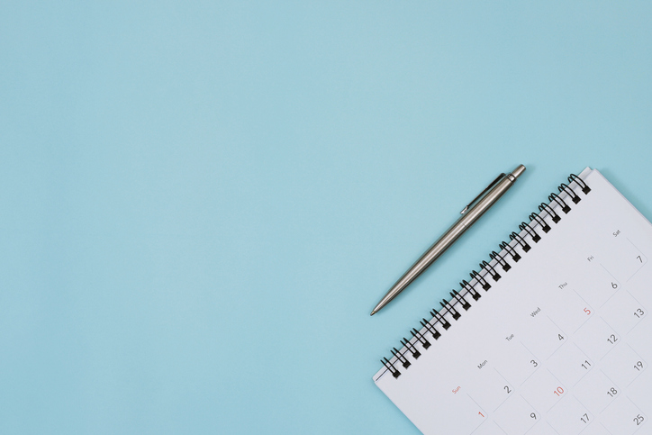 Calendar and pen on a blue background