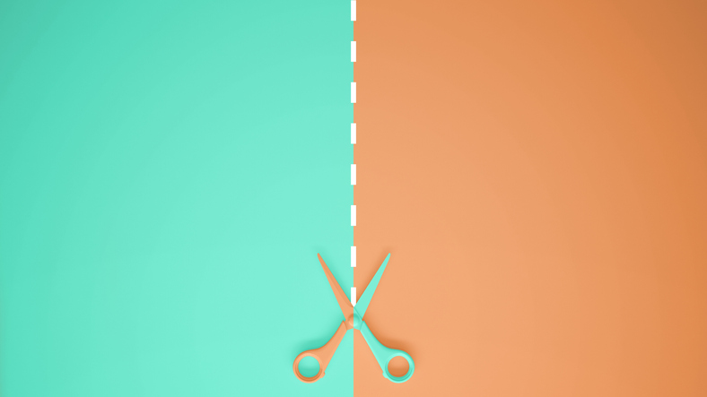 Scissors cut a piece of paper into one green side and one brown side
