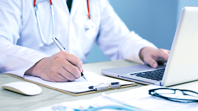 Vet sitting at laptop writing notes