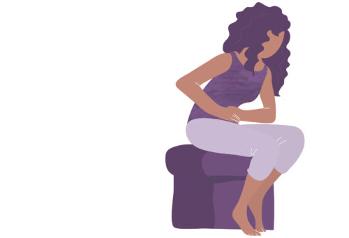 A person sitting on a chair with her hands on her stomach, bent over with abdominal pain showing that financial health can affect your physical health.