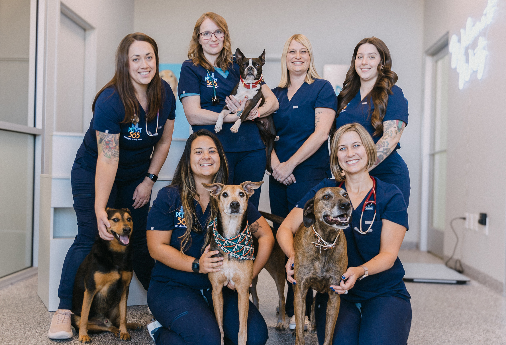 Group photo of the team at PetVet365 all wearing the same dark blue monogrammed scrubs.