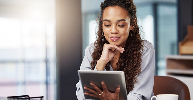 Image of a woman looking at a tablet for a job. Hiring and retaining employees is important.