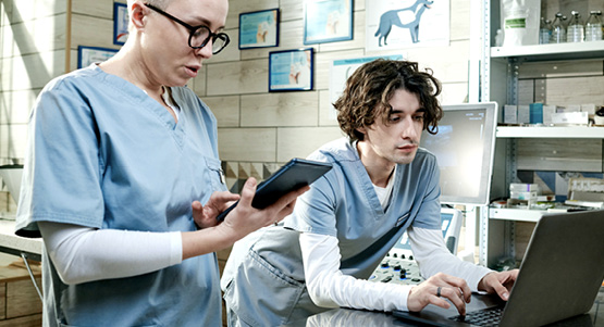 2 people in scrubs on phones