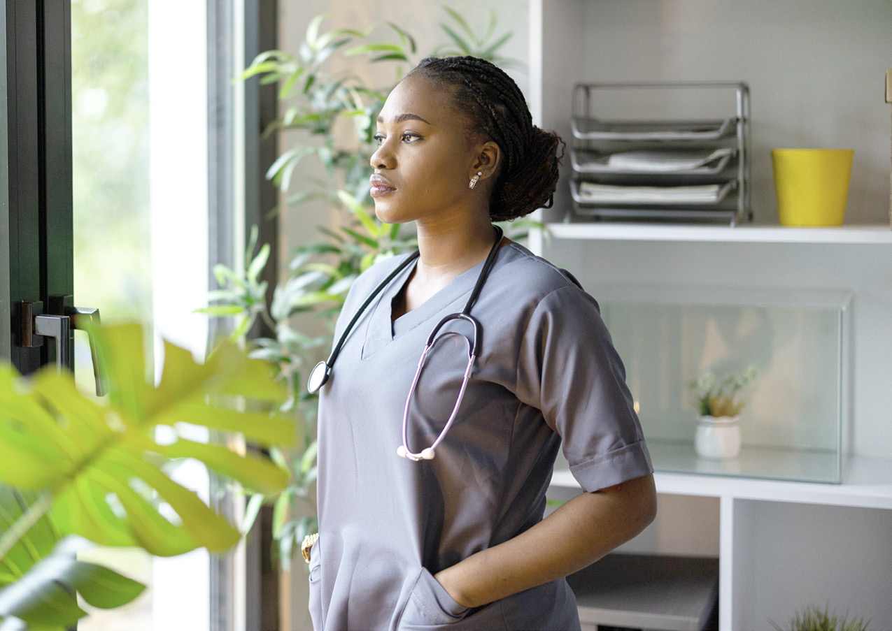 medical person in scrubs looking pensive