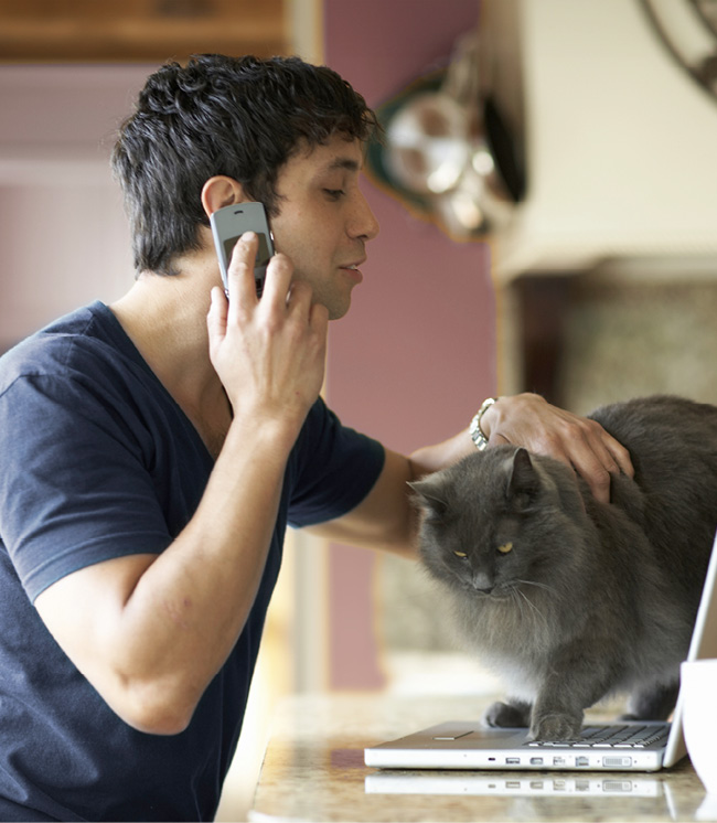 man on the phone while comforting his dog