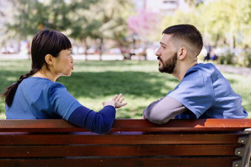 2 people on a bench talking
