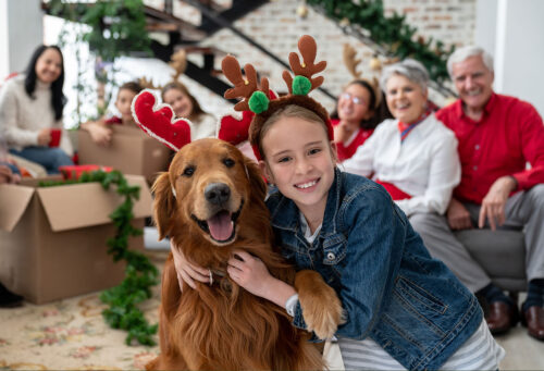 Family posing with pet at holiday party
